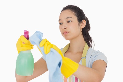 Local cleaner tidying a bright kitchen in Queens Park